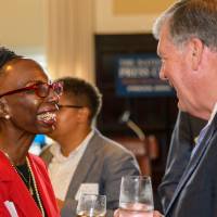 Woman introduces herself and smiles with President Haas